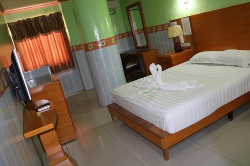 een slaapkamer met een bed met zwanen erop bij Jeamco Royal Hotel-General Santos in General Santos