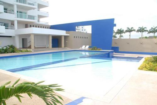 a swimming pool in front of a building at Resort Playa Azul in Tonsupa