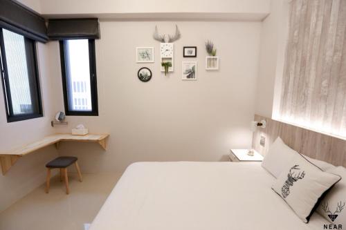 a bedroom with a bed and a desk and windows at NEAR B&b 2283 in Hualien City