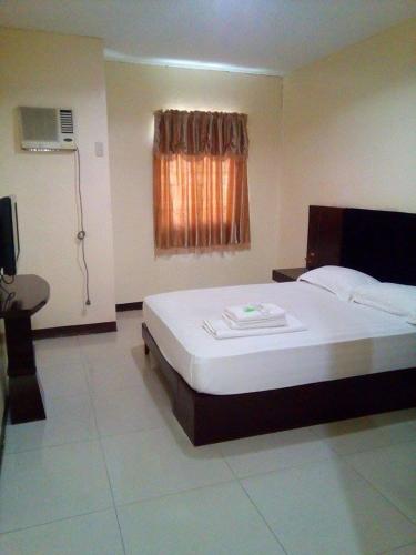 Un dormitorio con una cama grande y una ventana en Asia Novo Boutique Hotel - Ozamis, en Ozamis