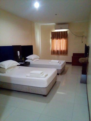 2 Betten in einem Hotelzimmer mit in der Unterkunft Asia Novo Boutique Hotel - Ozamis in Ozamis
