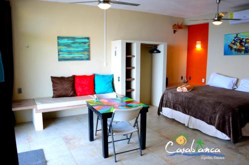 Casablanca Guest House - Adults Only - Starlink Internet! في زيبوليت: غرفة نوم بسرير وطاولة واريكة