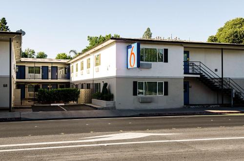a white building with a sign on the side of it at Motel 6-Modesto, CA - Downtown in Modesto