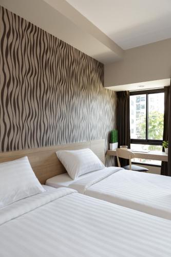 a bedroom with two beds and a zebra patterned wall at @S115 Residence in Samutprakarn