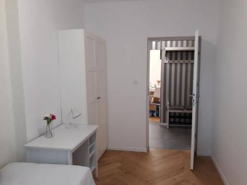 a white bedroom with a desk and a mirror at 2 Bedroom City Center Apartment in Katowice