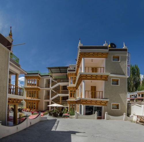 a large apartment building with a patio in front of it at Hotel Om Ladakh in Leh