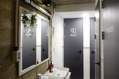 a bathroom with a sink and a mirror at The Cube Hotel in Seoul