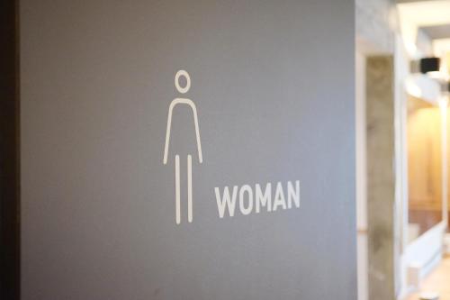 a sign on a door with a symbol of a woman at The Cube Hotel in Seoul