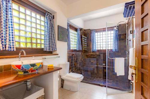 a bathroom with a toilet and a sink and a shower at Tequila Sunrise Sky Cabana-Diani Beach in Diani Beach