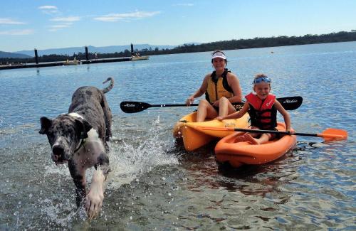 a woman and a girl and a dog in the water at South Coast Retreat in Greenwell Point