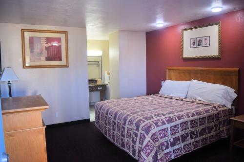 a hotel room with a bed and a mirror at Western Inn & Suites in Taft