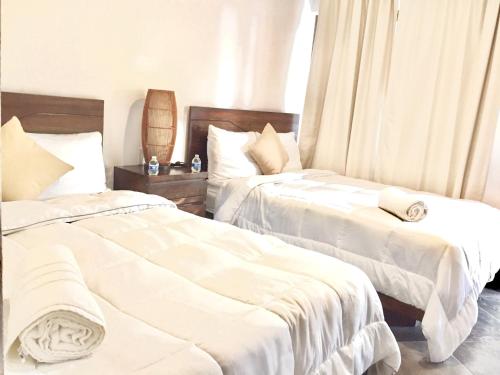 two beds sitting next to each other in a bedroom at Hotel Sun Ha Bacalar in Bacalar
