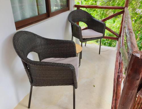 two chairs and a table on a porch at Hotel Sun Ha Bacalar in Bacalar