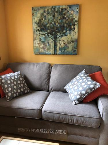 a gray couch with pillows on it in a living room at Sawing Logzz Cabin in Copper Center