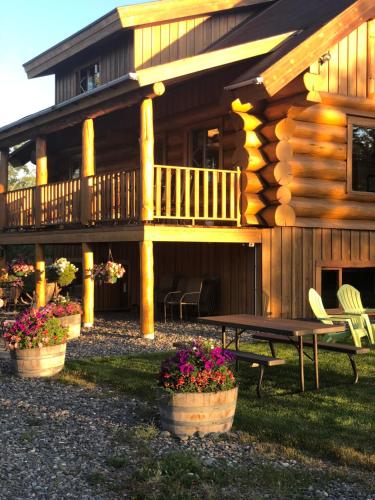 a log cabin with a picnic table in front of it at Sawing Logzz Cabin in Copper Center