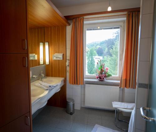 a bathroom with a sink and a window at Hotel Erika in Bad Reichenhall