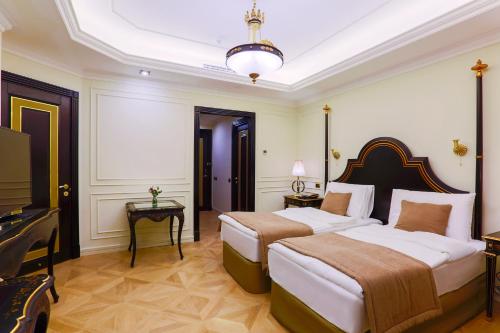 a hotel room with two beds and a television at Golden Palace Hotel Yerevan in Yerevan