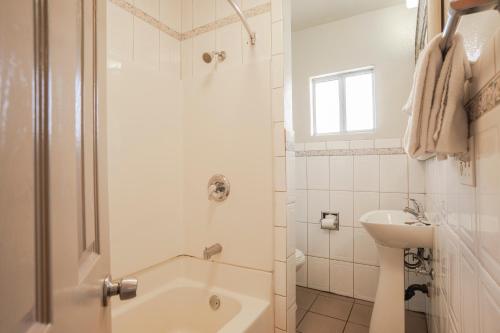 
a white toilet sitting next to a bath tub in a bathroom at Economy Inn Hollywood in Los Angeles
