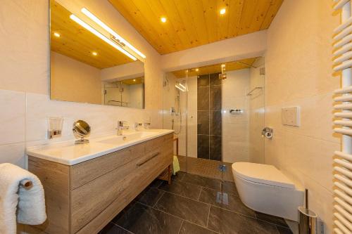 ein Bad mit einem Waschbecken, einer Dusche und einem WC in der Unterkunft Beim Gschdoaga in Mittenwald