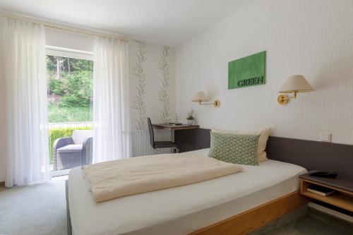 a bedroom with a bed in a room with a window at Luckai Hotel & Restaurant Inhaber Dennis Burmann in Freienohl