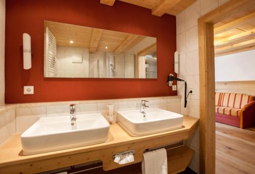 a bathroom with two sinks and a mirror at Hotel Natur-Landhaus Krone in Maierhöfen