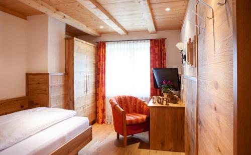 a bedroom with a bed and a desk with a chair at Hotel Natur-Landhaus Krone in Maierhöfen