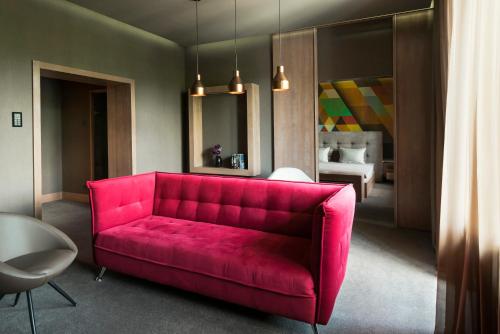 
a red couch sitting in a living room at Jolly Alon Hotel in Chişinău
