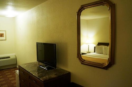 a hotel room with a television and a mirror at Waterford Inn in Waterford