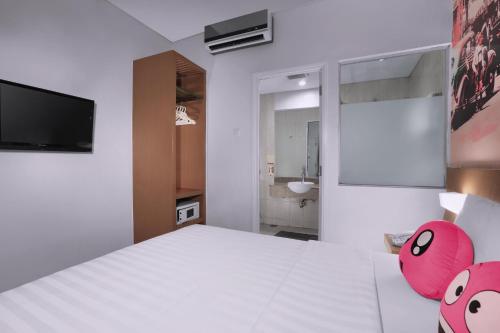 a bedroom with a large white bed with pink pillows at favehotel Braga in Bandung
