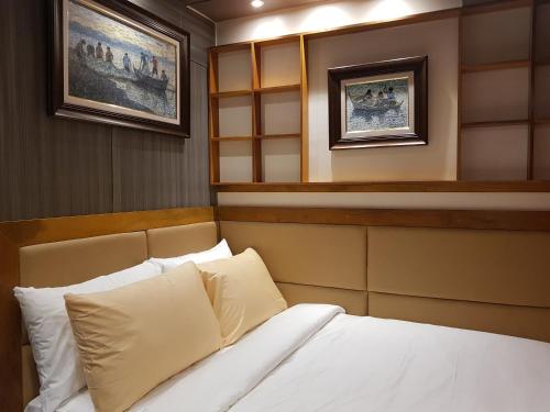 a bedroom with a bed and two pictures on the wall at Stay Amare Green La Salle Taft in Manila