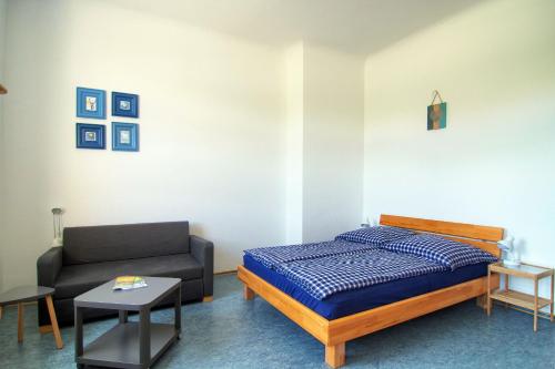een slaapkamer met een bed en een bank bij Ferienwohnung Renchglück in Renchen