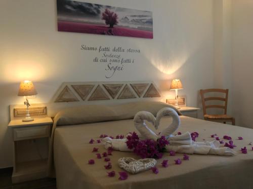 a bedroom with a bed with two hearts and flowers at Monti di Jogliu in Arzachena