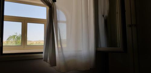a window with a white curtain in a room at Agriturismo Augello in Partanna