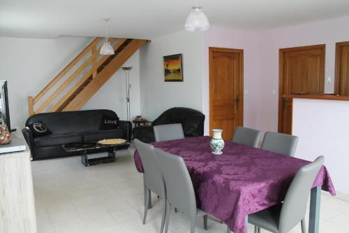 una sala da pranzo con tavolo e sedie viola di 18B Rue Winston Churchill a Jonzac