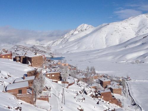 a town in the snow with a mountain in the background at Chalet tizrag in Oukkainrdem