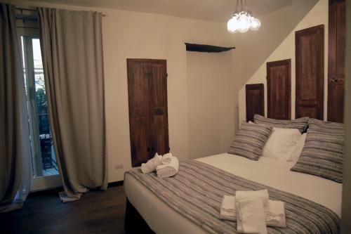 a bedroom with a bed with towels on it at La Canonica - charming self-catering apartments in Nizza Monferrato in Nizza Monferrato