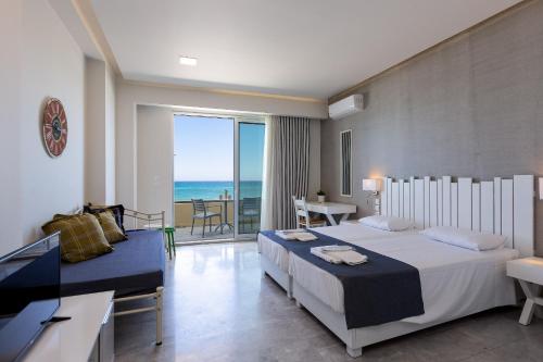 a hotel room with two beds and a view of the ocean at Meltemi Coast Suites in Rethymno Town