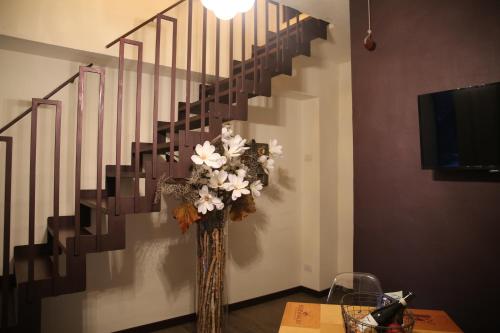 a vase filled with flowers sitting next to a staircase at La Canonica - charming self-catering apartments in Nizza Monferrato in Nizza Monferrato