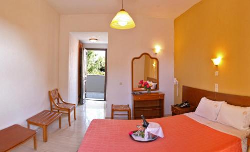 Habitación de hotel con cama y espejo en Pasiphae Hotel en Skala Kallonis