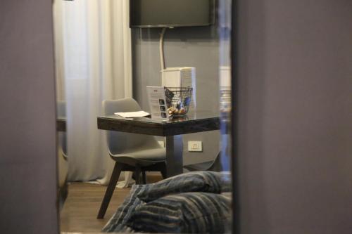 a desk in a room with a chair and a table at La Canonica - charming self-catering apartments in Nizza Monferrato in Nizza Monferrato