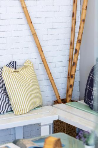 a bench with two pillows on it next to a brick wall at Meltemi Coast Suites in Rethymno Town