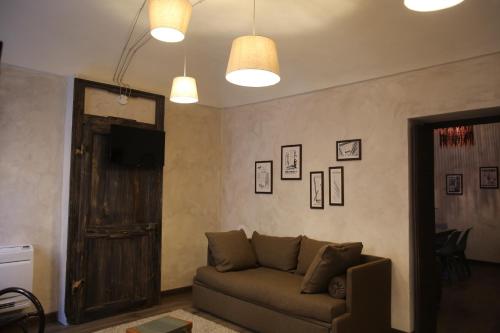 a living room with a couch and a door at La Canonica - charming self-catering apartments in Nizza Monferrato in Nizza Monferrato