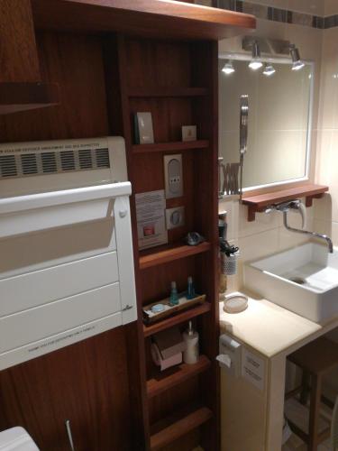 - une petite cuisine avec un évier et un miroir dans l'établissement La Coloniale, à Saint-Malo