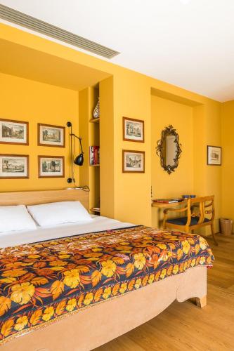 a bedroom with a large bed with yellow walls at Rarity Suites in Rome
