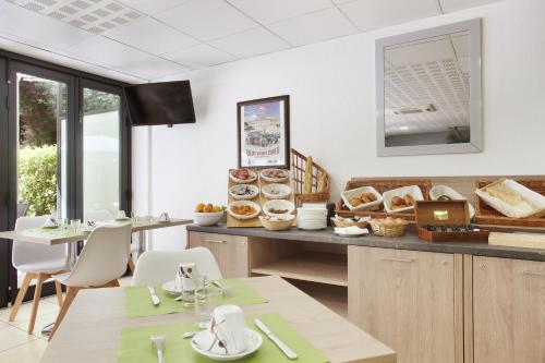 a restaurant with a counter with pastries on it at Appart'hôtel Odalys City - Monaco Les Hauts de la Principauté in Beausoleil
