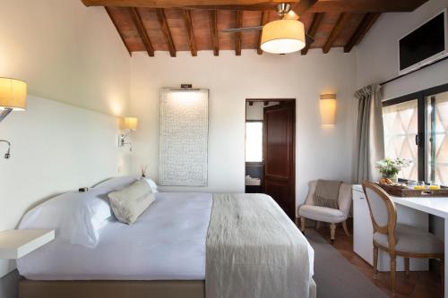 a bedroom with a large white bed and a desk at Locanda Le Piazze in Castellina in Chianti