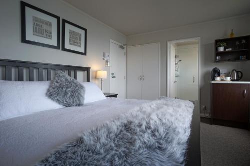 a bedroom with a white bed with a furry blanket at Lands End in Bluff