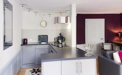 a kitchen with white cabinets and a counter top at Seesterne City in Konstanz