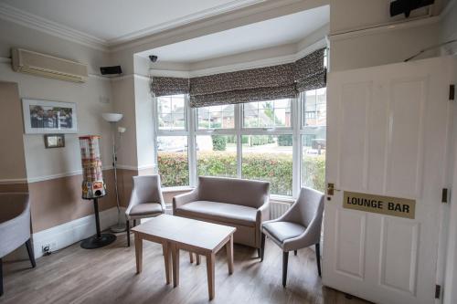 a waiting room with chairs and a table and a door at Corner House Hotel Gatwick with bookable Holiday parking in Horley