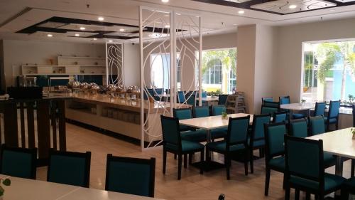 a restaurant with tables and chairs and a bar at Harbour View Hotel in Kuching